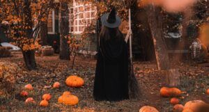 witch in a yard with pumpkins