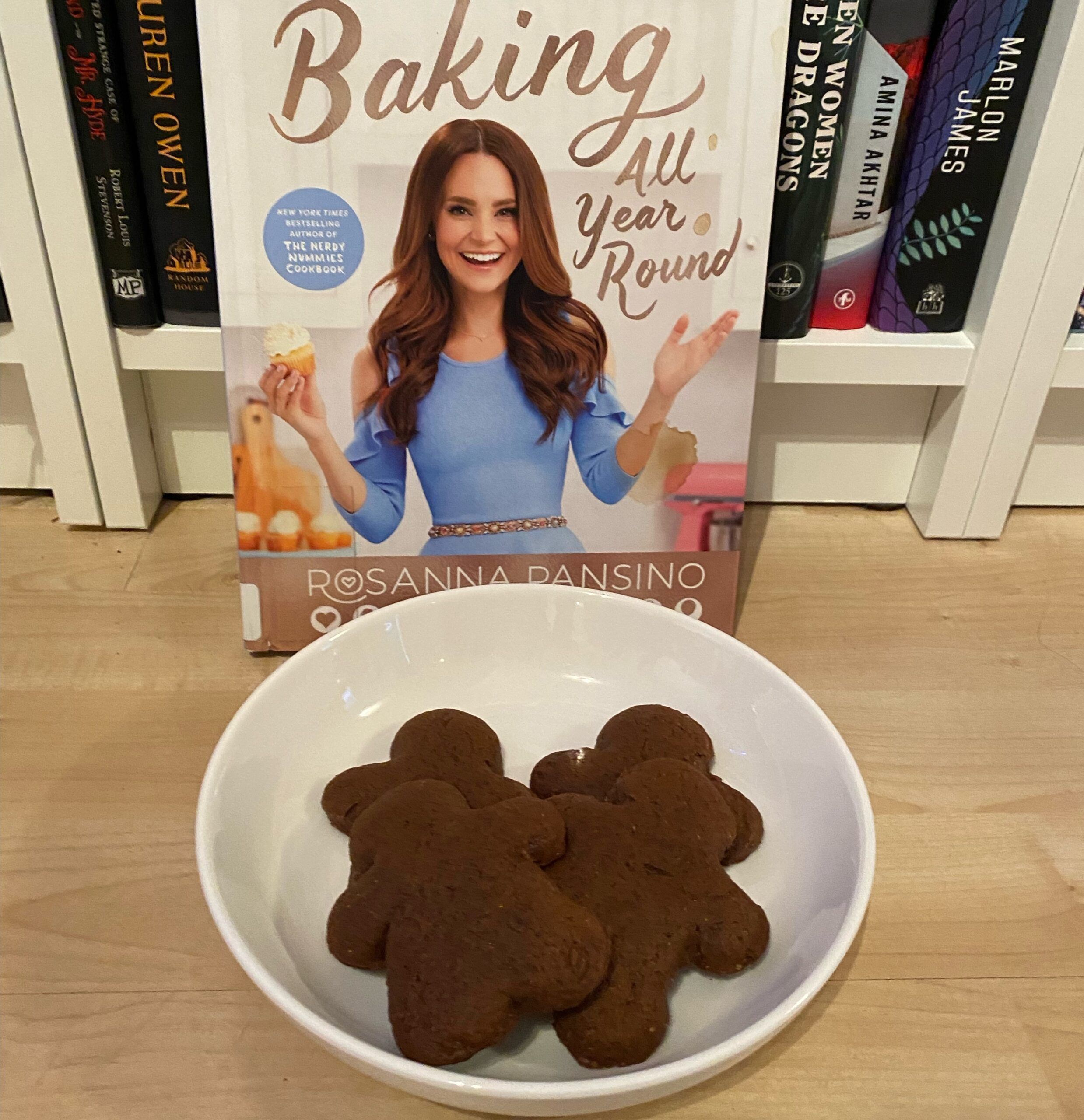 A plate of gingerbread cookies in front of the Baking All Year Round cookbook