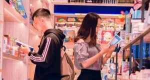 Two light-skinned Asian people reading books in a bookstore