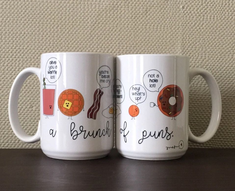 Image of two sides of a white mug. It has several breakfast foods on it, with the words "a brunch of puns." The food images have puns in text, such as "olive you a waffle lot" and "not a hole lot."