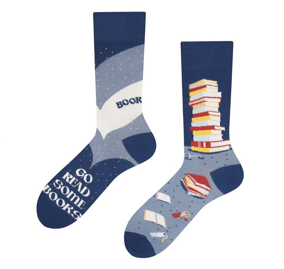 Image of a pair of blue socks that feature stacks of books. The socks red "go read some books." 