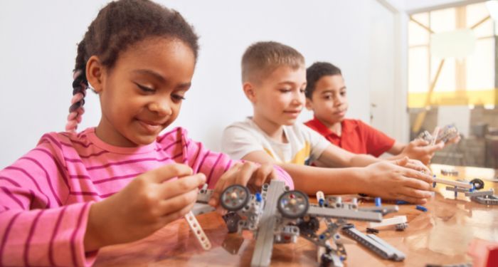 Image of three kids building robots
