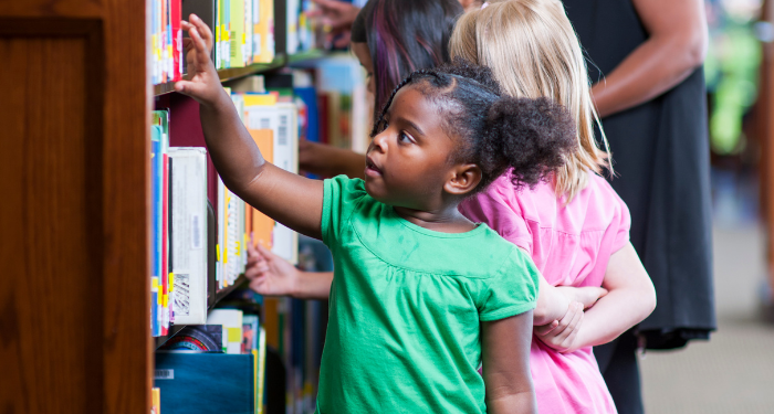 a photo of a group of kids browsing at a library