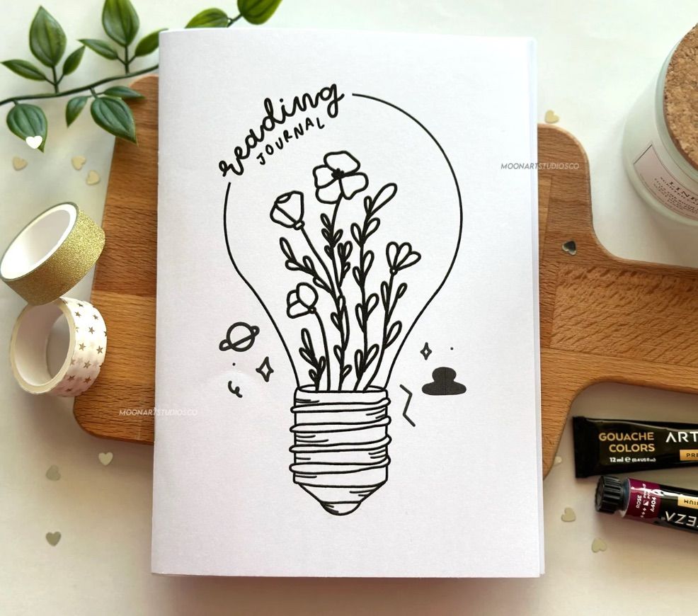 Image of a small notebook. It has a lightbulb wwith flowers inside and says 