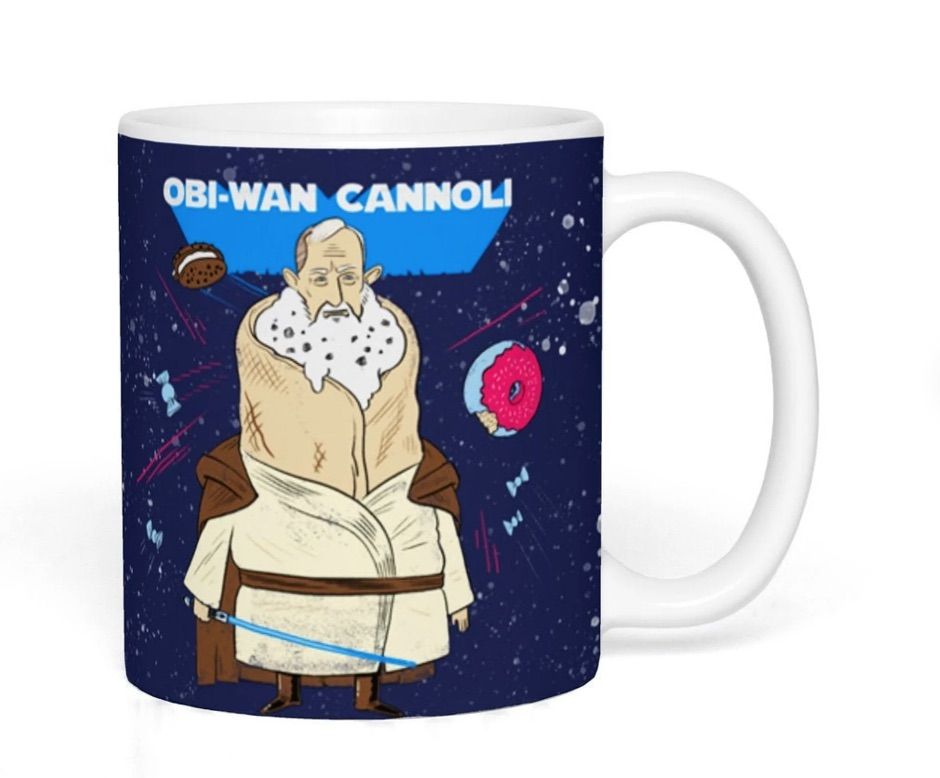 Image of a dark blue mug. It reads "obi-wan cannoli" and features the star wars character imagined as a cannoli. 