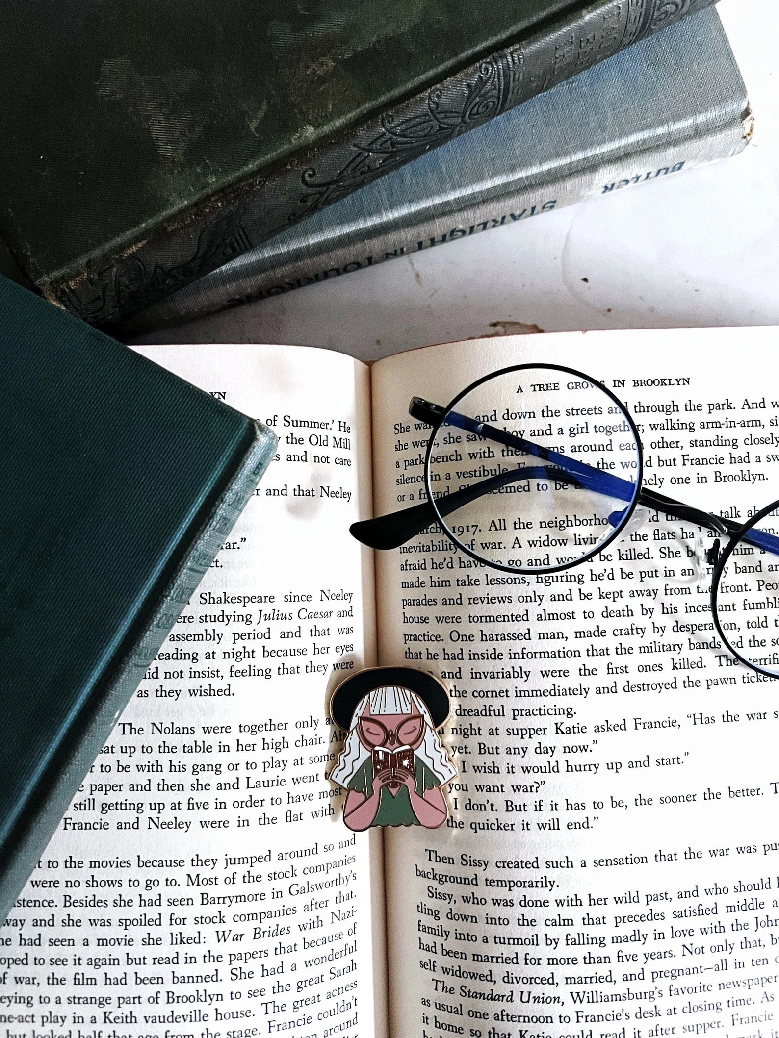 an enamel pin of a woman inhaling a book