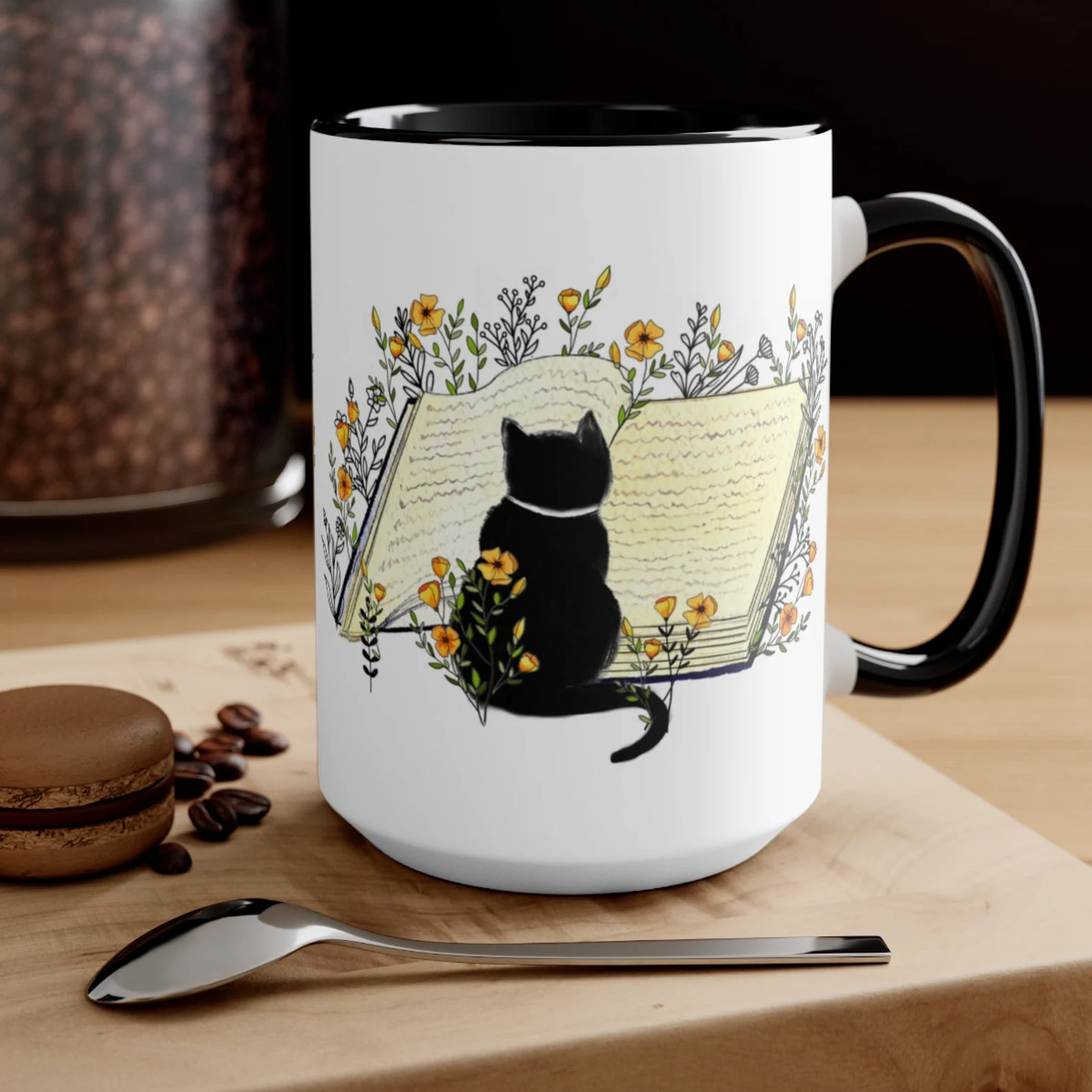 black and white mug depicting a black cat reading an open book surrounded by orange flowers