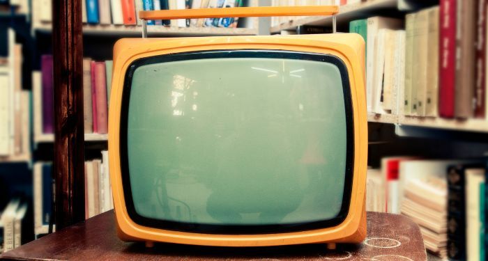 Image of a vintage TV in front of bookshelves