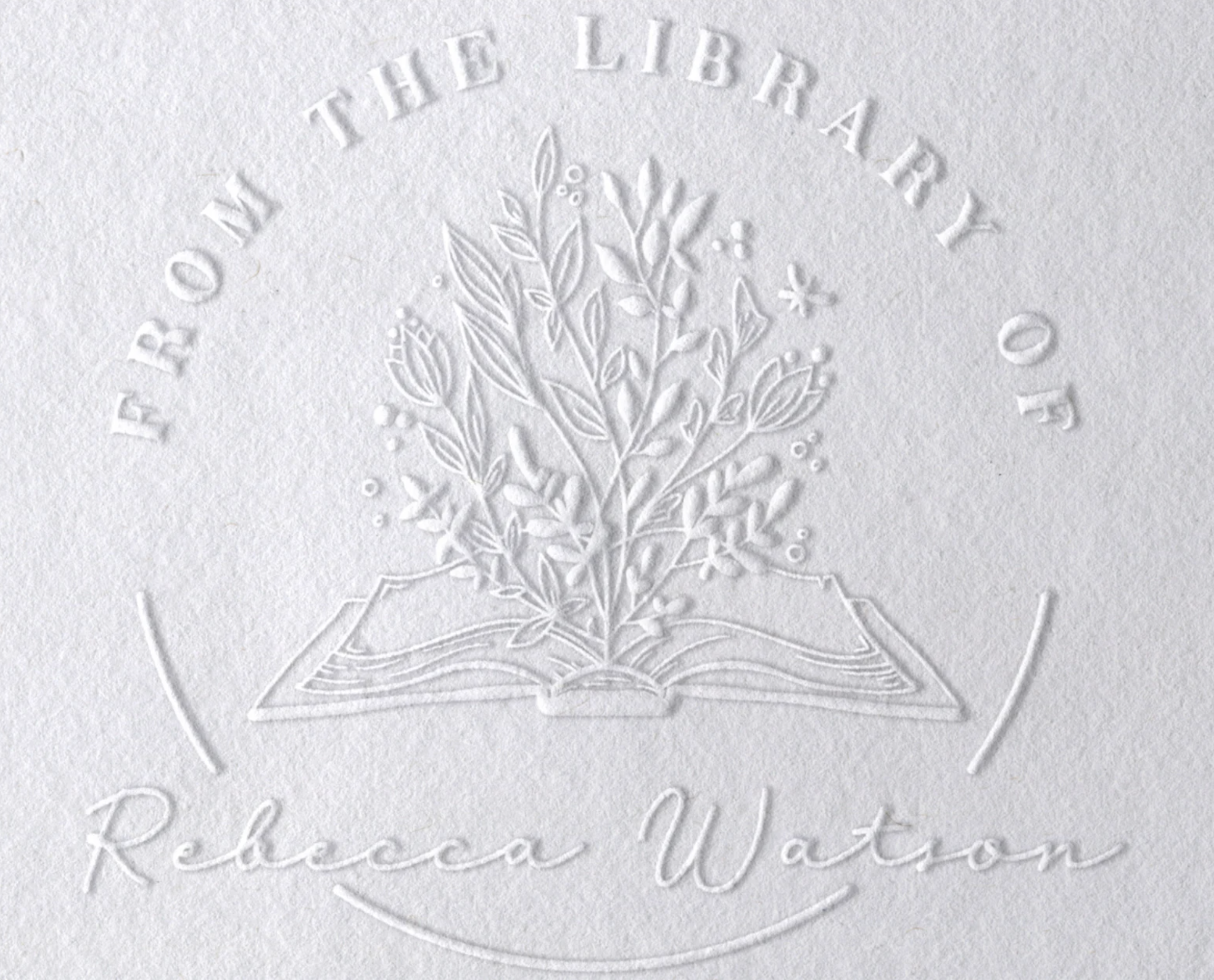A white page with an embossed book and flowers. the text says "From the library of Rebecca Watson"