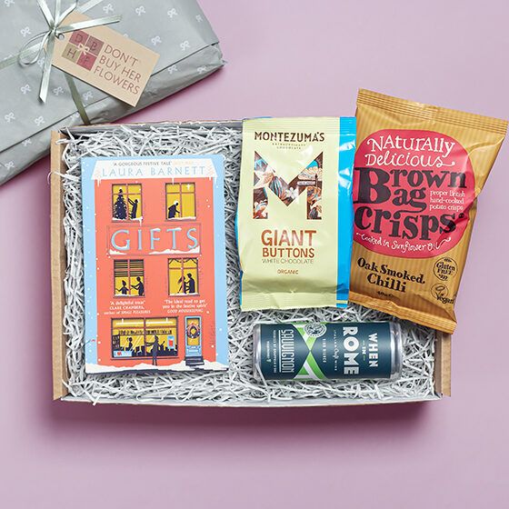 a photo of a Book Gift box with paperback book, snacks, and a drink inside