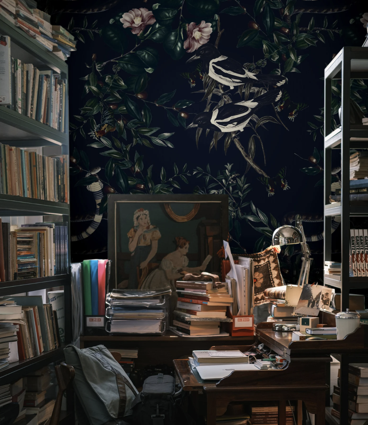 A cluttered reading room with dark wallpaper behind it, covered in foliage and magpies. 