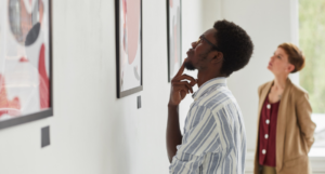 a photo of two people looking at modern art hung on a wall