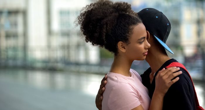Image of a Black teen couple embracing