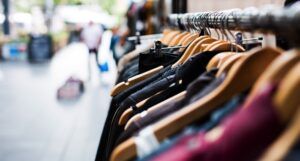 clothes hanging on a rack. on a sidewalk