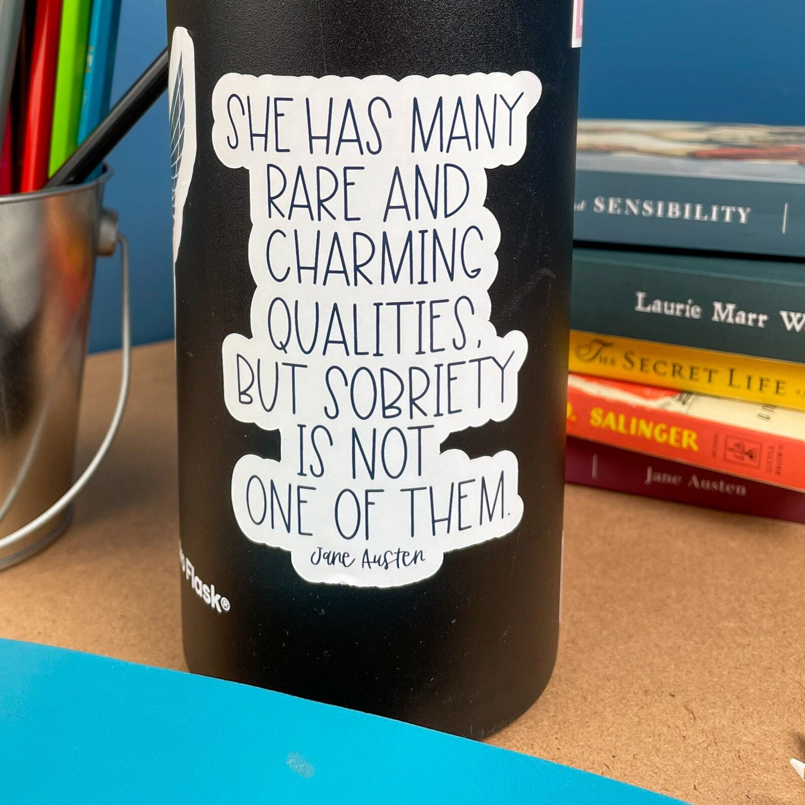 a white vinyl sticker that reads "She has many rare and charming qualities, but sobriety is not one of them"