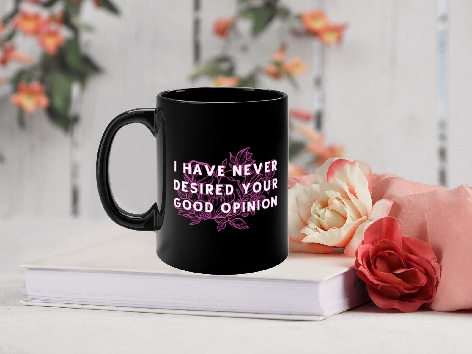 A black mug with pink flowers and the words "I have never desired your good opinion"