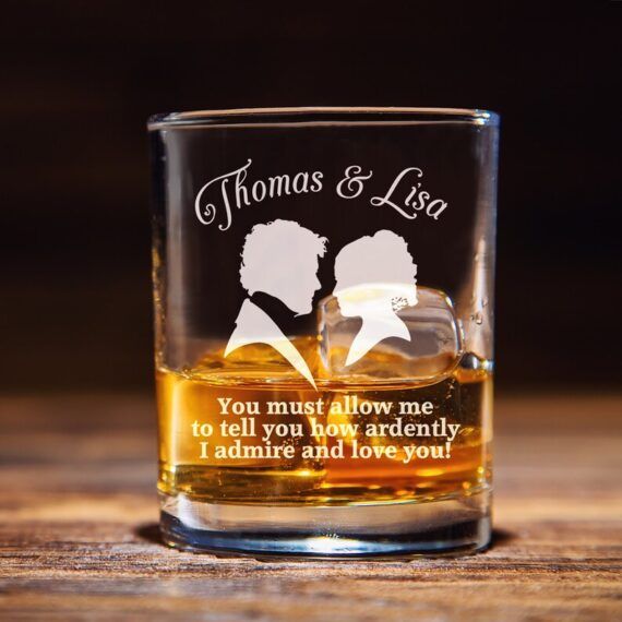 image of a clear glass with amber liquid, engraved with a jane austen quote, the silhouettes of a couple, and a couple's names