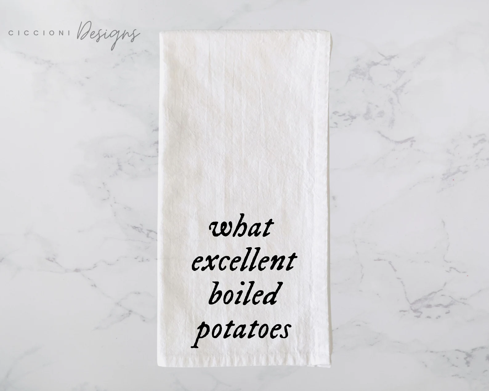 a white tea towel that reads, in black cursive "What excellent boiled potatoes!"