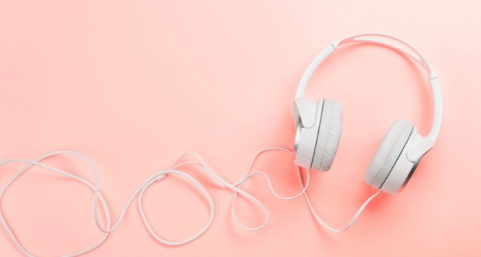 Image of white headphones on a pink background