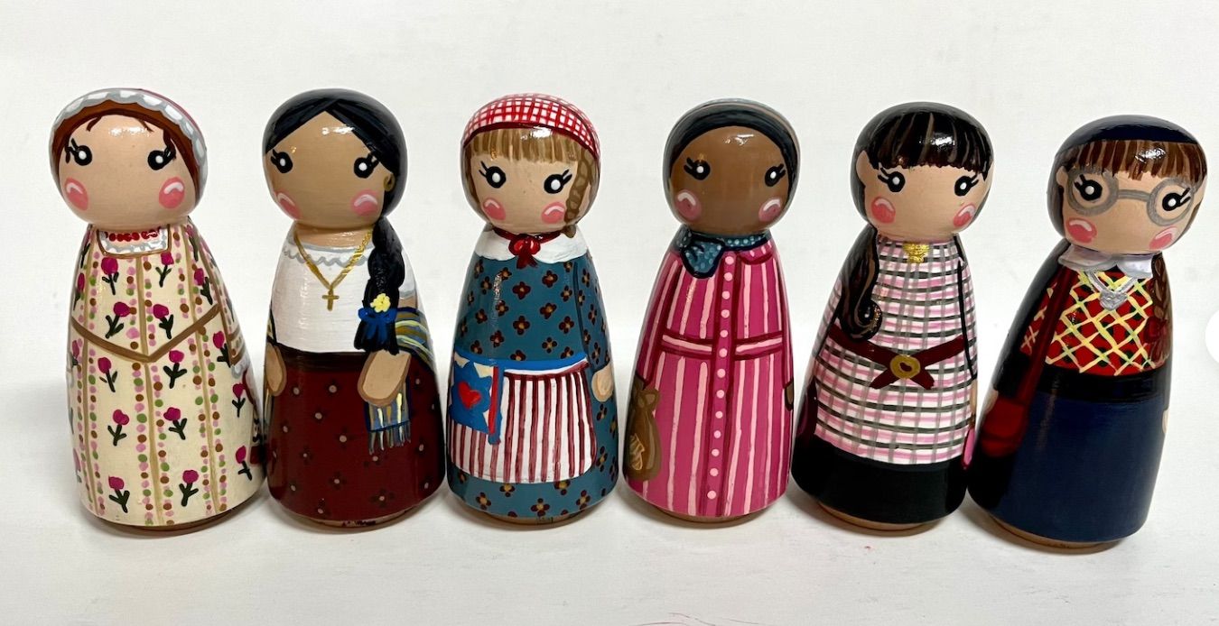 Image of hand painted peg dolls in the likeness of the original 6 American Girls.