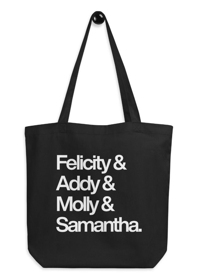 Image of a black tote with white text. It says "Felicity + Addy + Molly + Samantha."