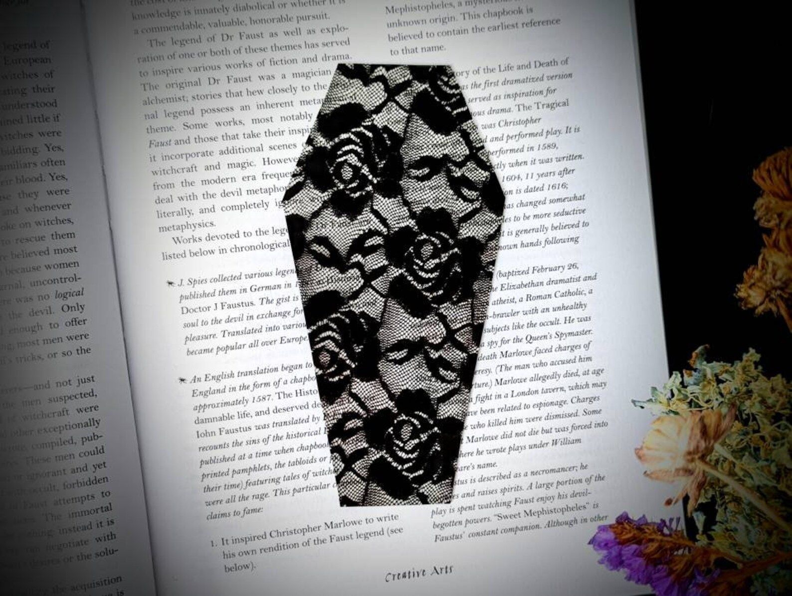 open page of a book with a coffin-shaped bookmark made of black lace