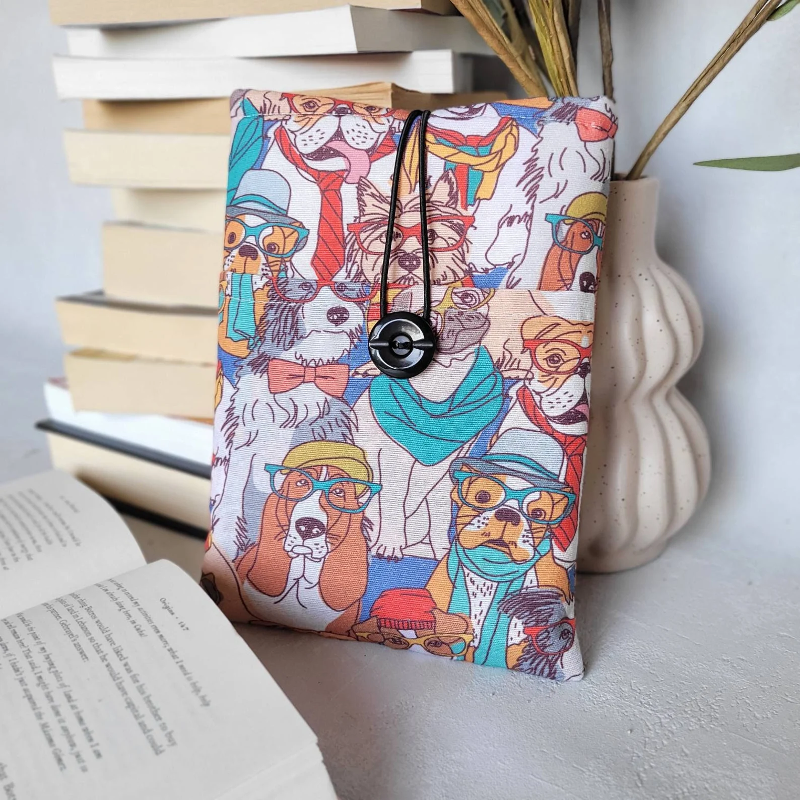 a book sleeve in a brightly colored print of dogs wearing glasses