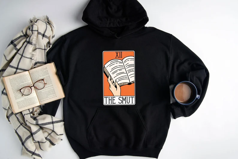 Black sweatshirt with a book, a hand, and Smut on it 