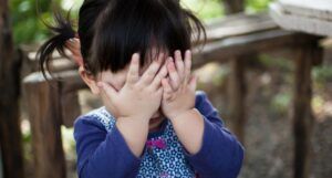 Image of a shy girl covering her face