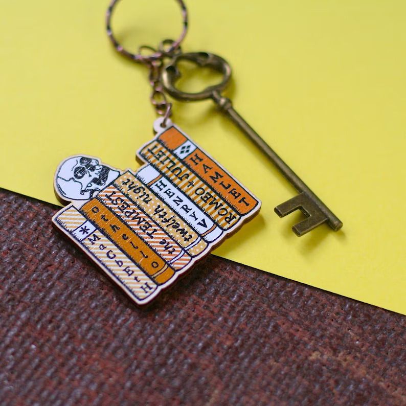 Photo of a keychain with books placed next to each other and the titles of Shakespeare books on the spine, a skull on top. 