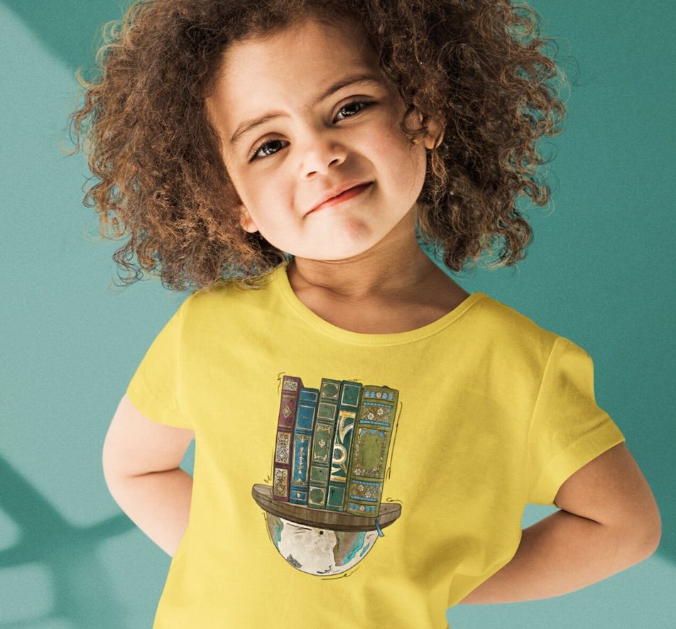 Image of a girl with olive skin wearing a yellow shirt. The shirt features a half a globe with several vintage-style book spines on it. 