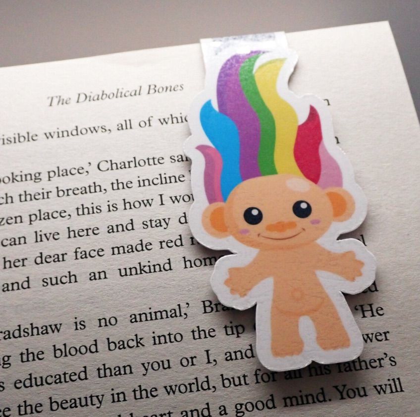 Image of a troll doll magnetic bookmark. The troll has rainbow hair. 