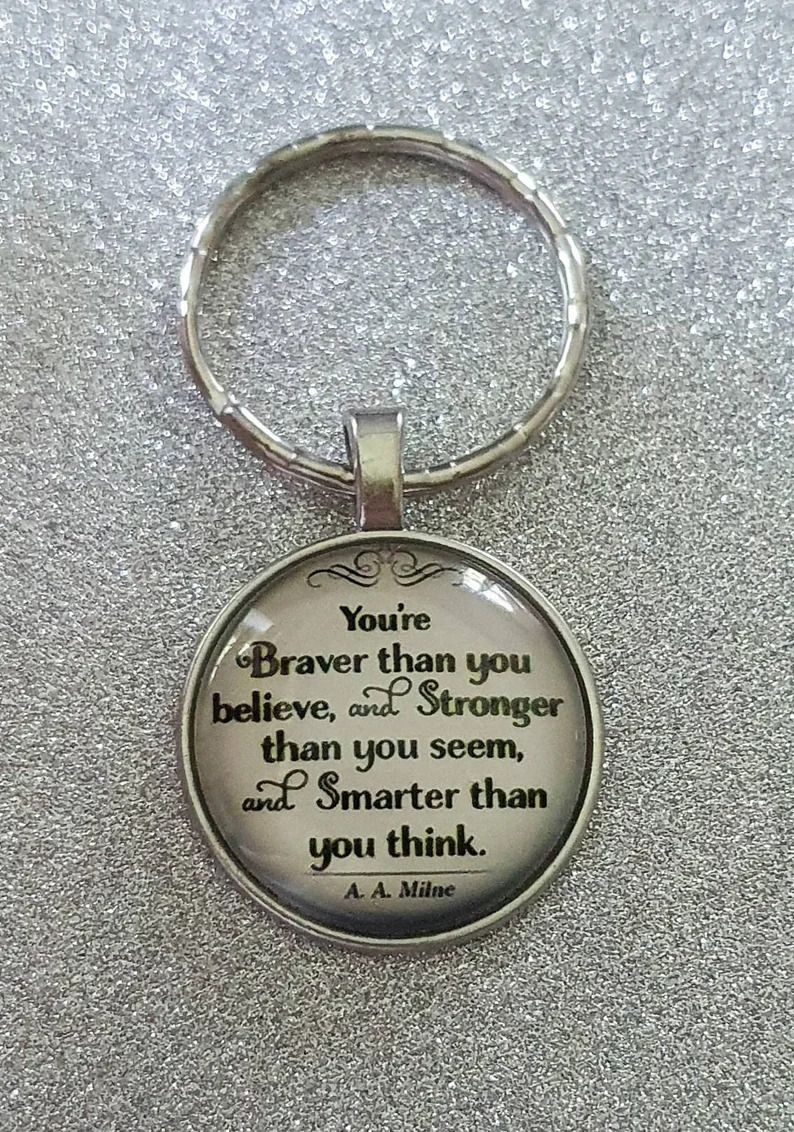 Photo of a round keychain with the quote You're braver than you believe and stronger than you seem and smarter than you think. 