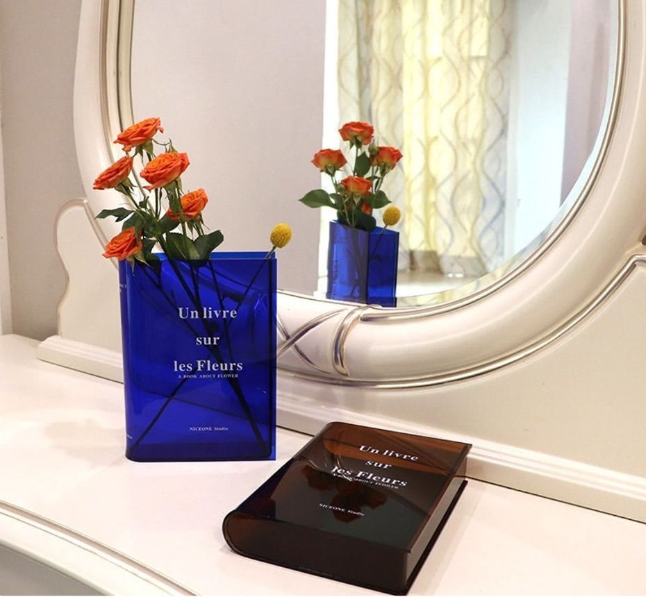 Image of a blue and brown transparent vase in the shape of a book.