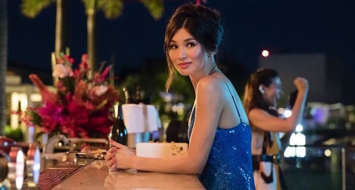 a still of Gemma Chan as Astrid in Crazy Rich Asians. She is dressed up andsitting at an outdoor bar.