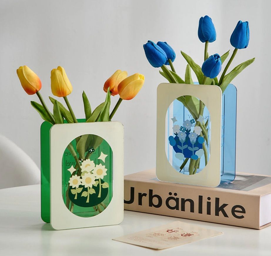 Set of two book-shaped vases. One is green and one is blue. 