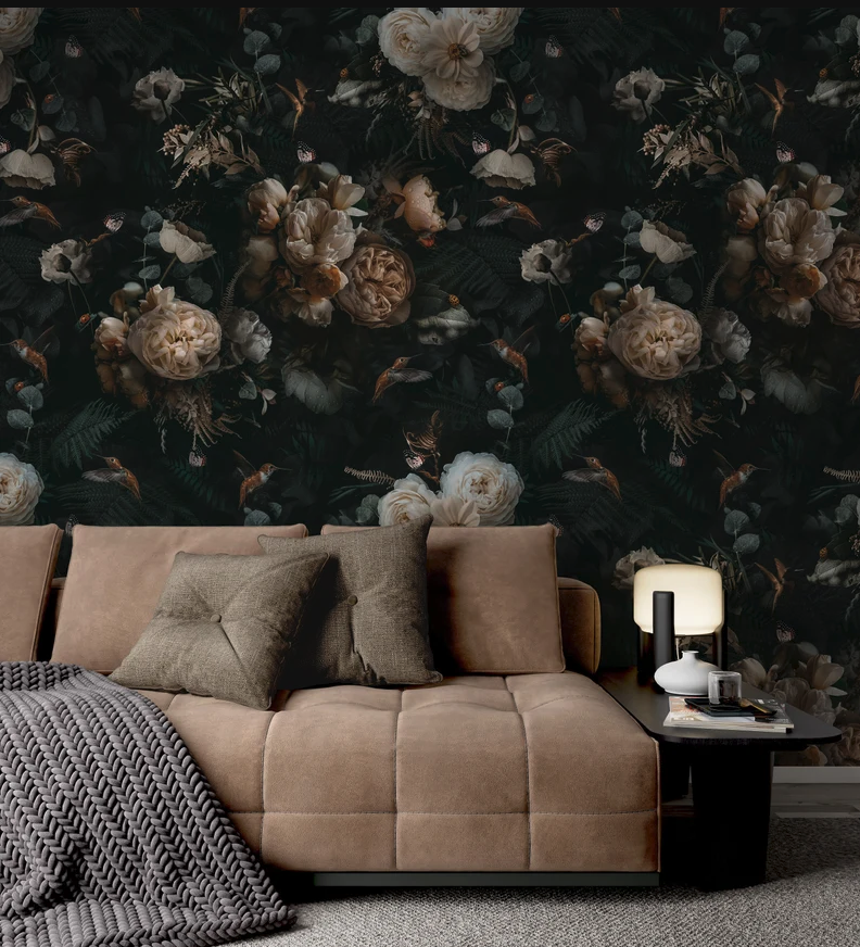 dark floral wallpaper behind a beige couch with a gray throw blanket