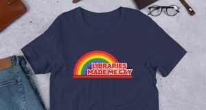 A navy t-shirt depicting a rainbow and the words "Libraries made me gay."