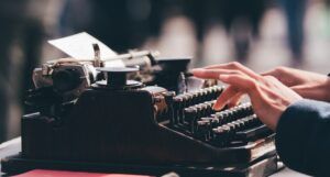 hands typing on an old-fashioned typewriter