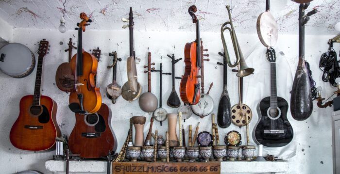 A variety of musical instruments hanging from a ceiling