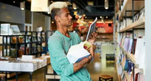 a photo of someone at a bookstore holding a stack of books