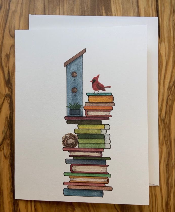 Image of a greeting card which has a cardinal and stack of books. 