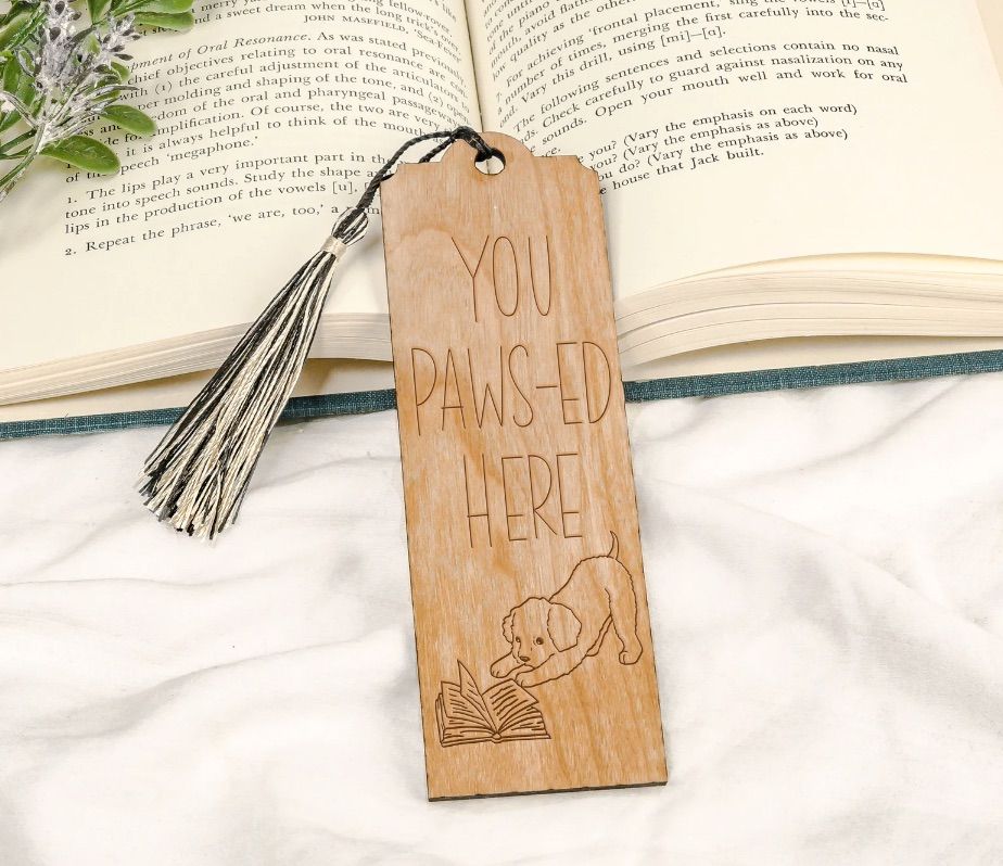 wooden bookmark that says "you paws-ed here" with a dog and a book image. 