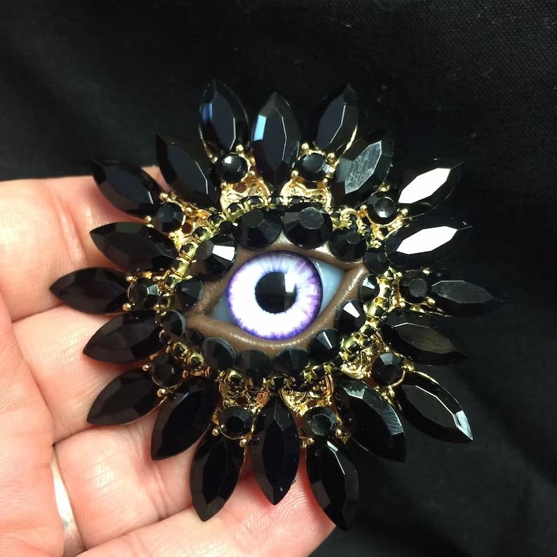 a black brooch with an eye in the middle
