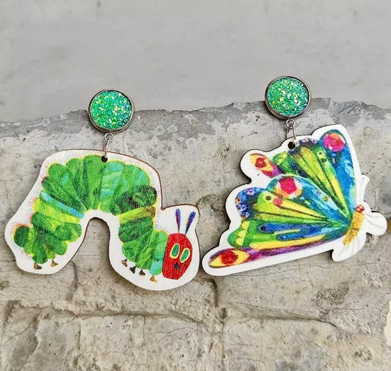 Image of a pair of earrings featuring the very hungry caterpillar and the butterfly it becomes. 