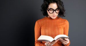 Image of a nerdy looking reader with a book