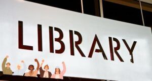 image of a library sign with a graphic featuring people raising their fists