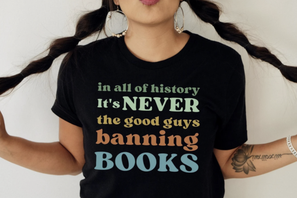 Black shirt reading "In all of history it's never the good guys banning books" in various colors