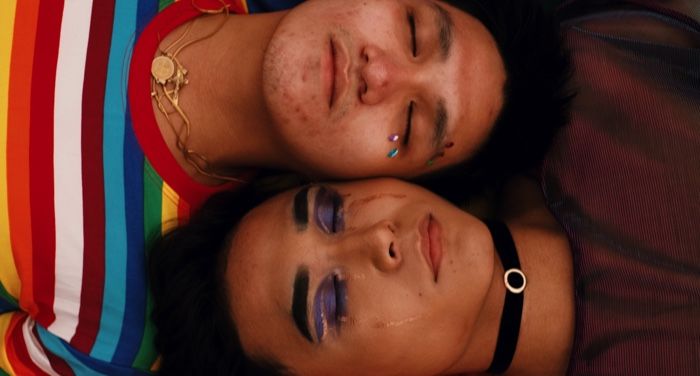 queer masc people with makeup lying next to each other