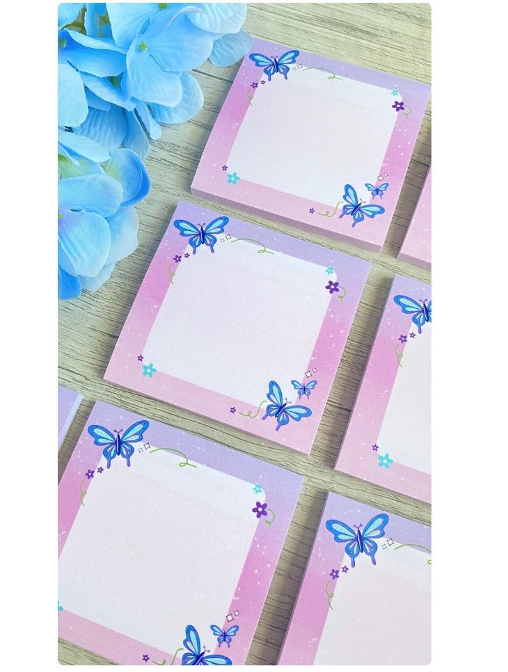 Image of several small notepads featuring blue butterflies. 